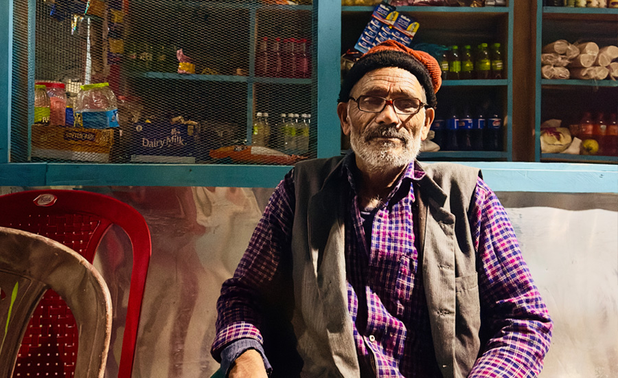 "Smiling homestay uncle welcoming guests with warm Garhwali hospitality in Uttarakhand