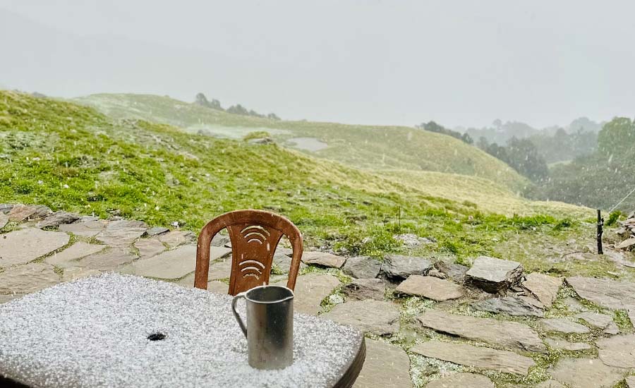 Hailstorm hitting a mountain trail with scattered white hailstones