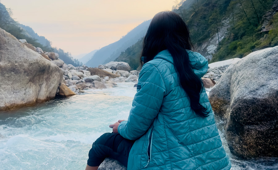 Leg dipped deep in the cold, flowing river—feeling the purity and calm of Himalayan waters