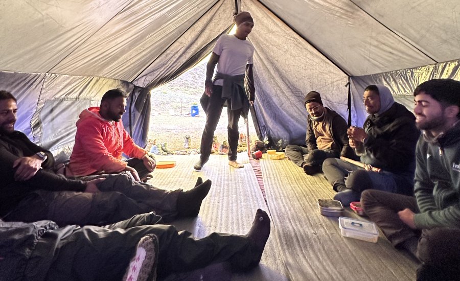 Trekkers playing games inside the Kanamo Base Camp community tent