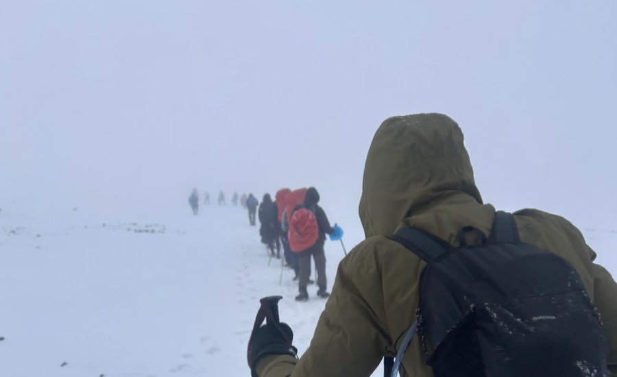 Trekkers making a trail through deep snow on Kanamo Peak